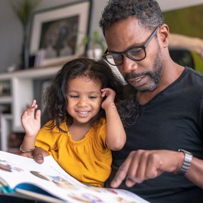 A father and daughter read a storybook together